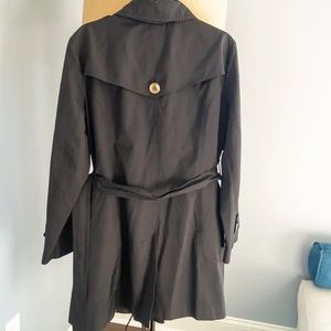 MICHAEL Michael Kors Double-Breasted Black Belted Trench with gold accents.